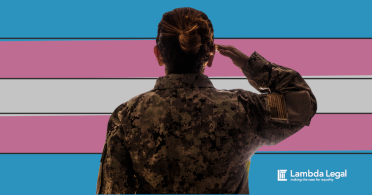 A person salutes in front of a transgender pride flag